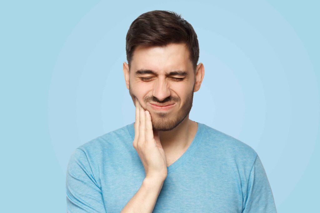 Man holding his jaw due to severe tooth pain.